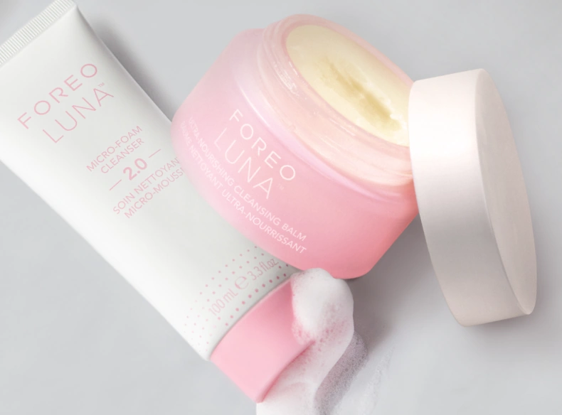 FOREO LUNA Ultra-Nourishing Cleansing Balm jar open next to a tube of Micro-Foam Cleanser 2.0