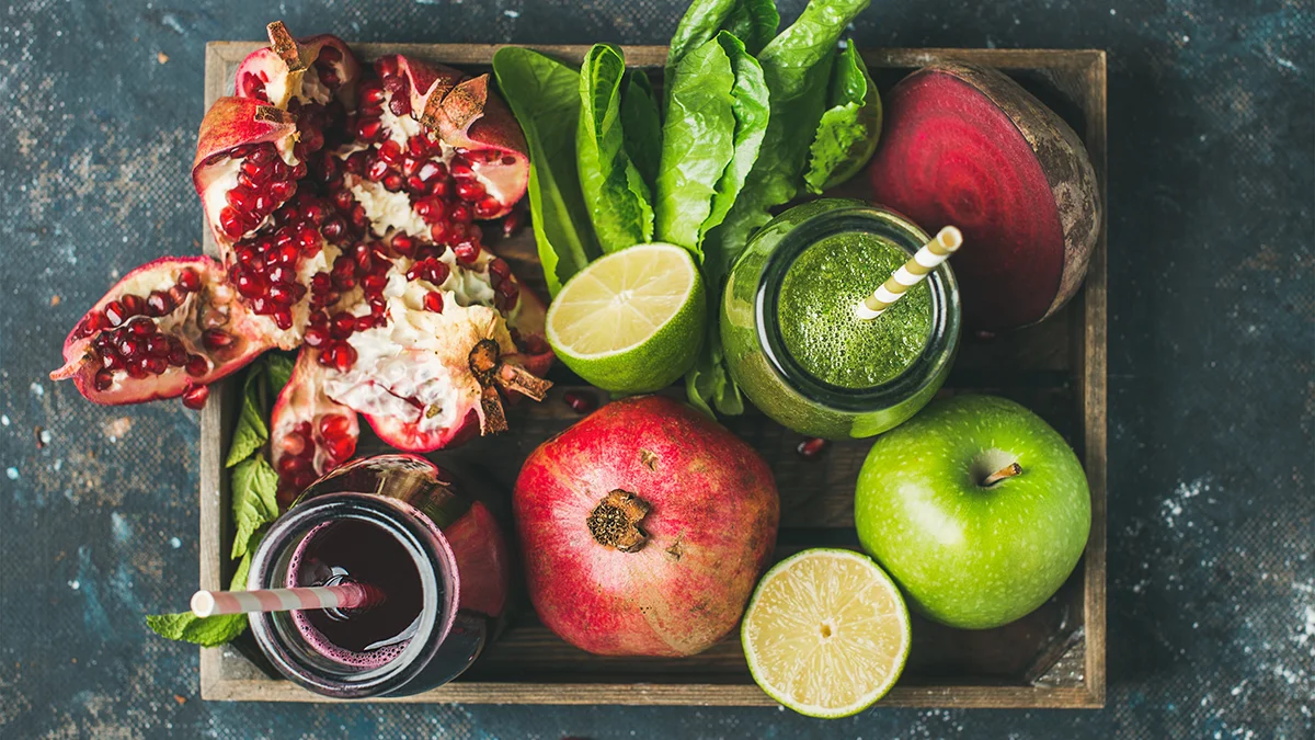 A wodden platter of antioxidant-rich fruits and vegetables and fresh juices