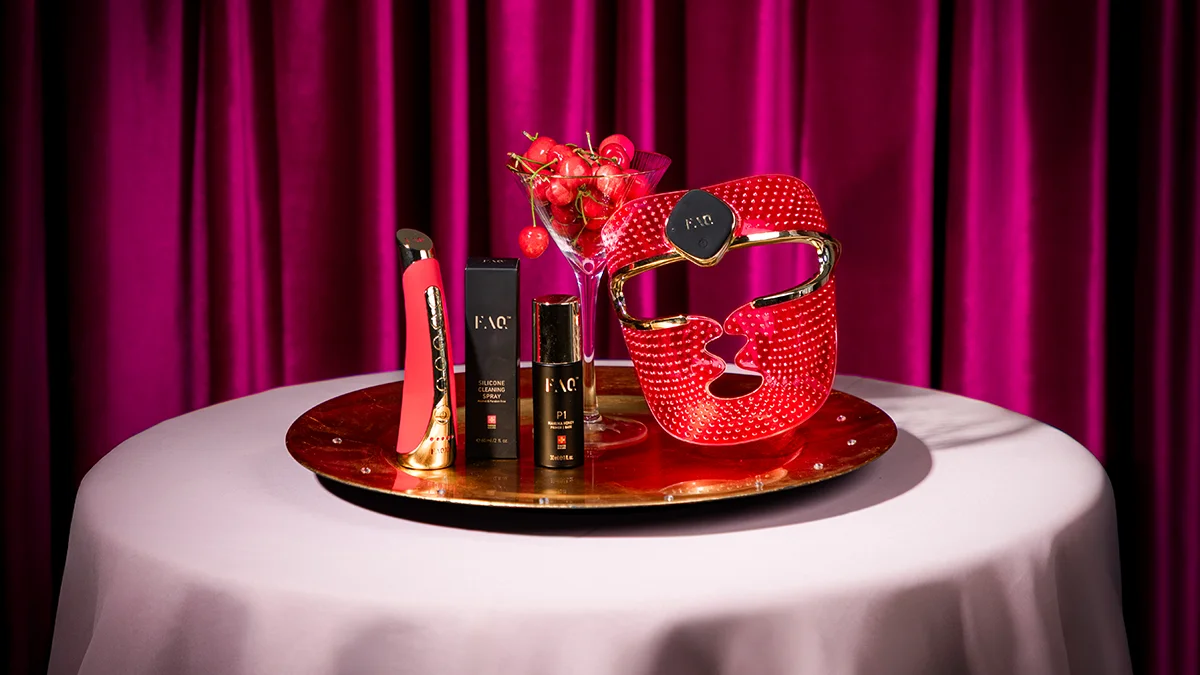 FAQ 202 led face mask and FAQ 102 on a gold plater on a table, purple rich curtains behind