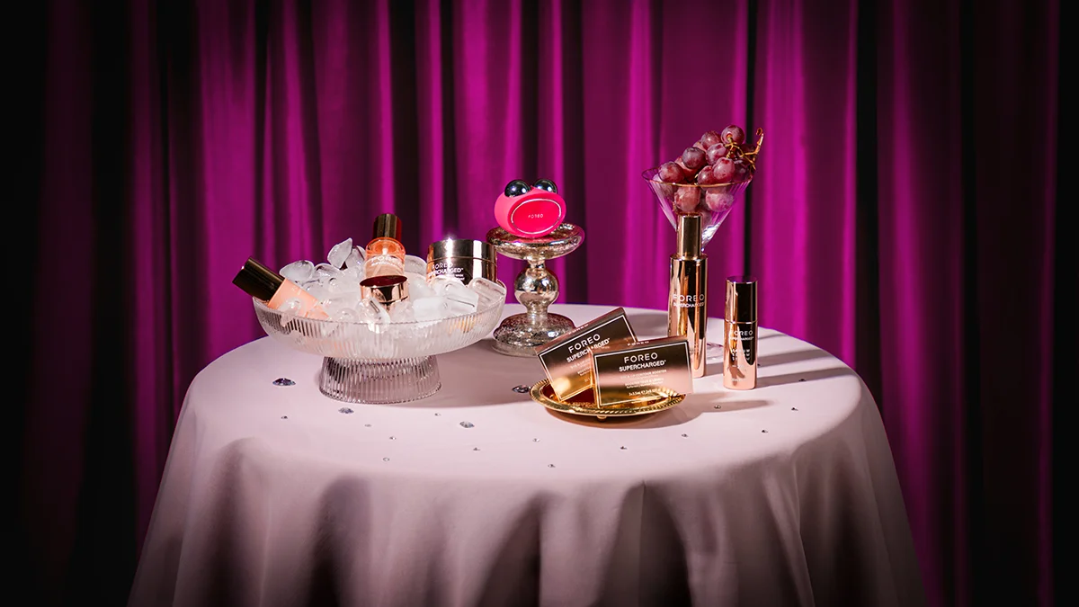 FOREO BEAR 2 microcurrent facial device and cosmetics on a fancy celebratory table