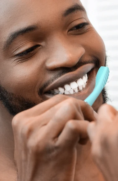 Smiling man brushing his teeth with a mint FOREO issa 4 toothbrush