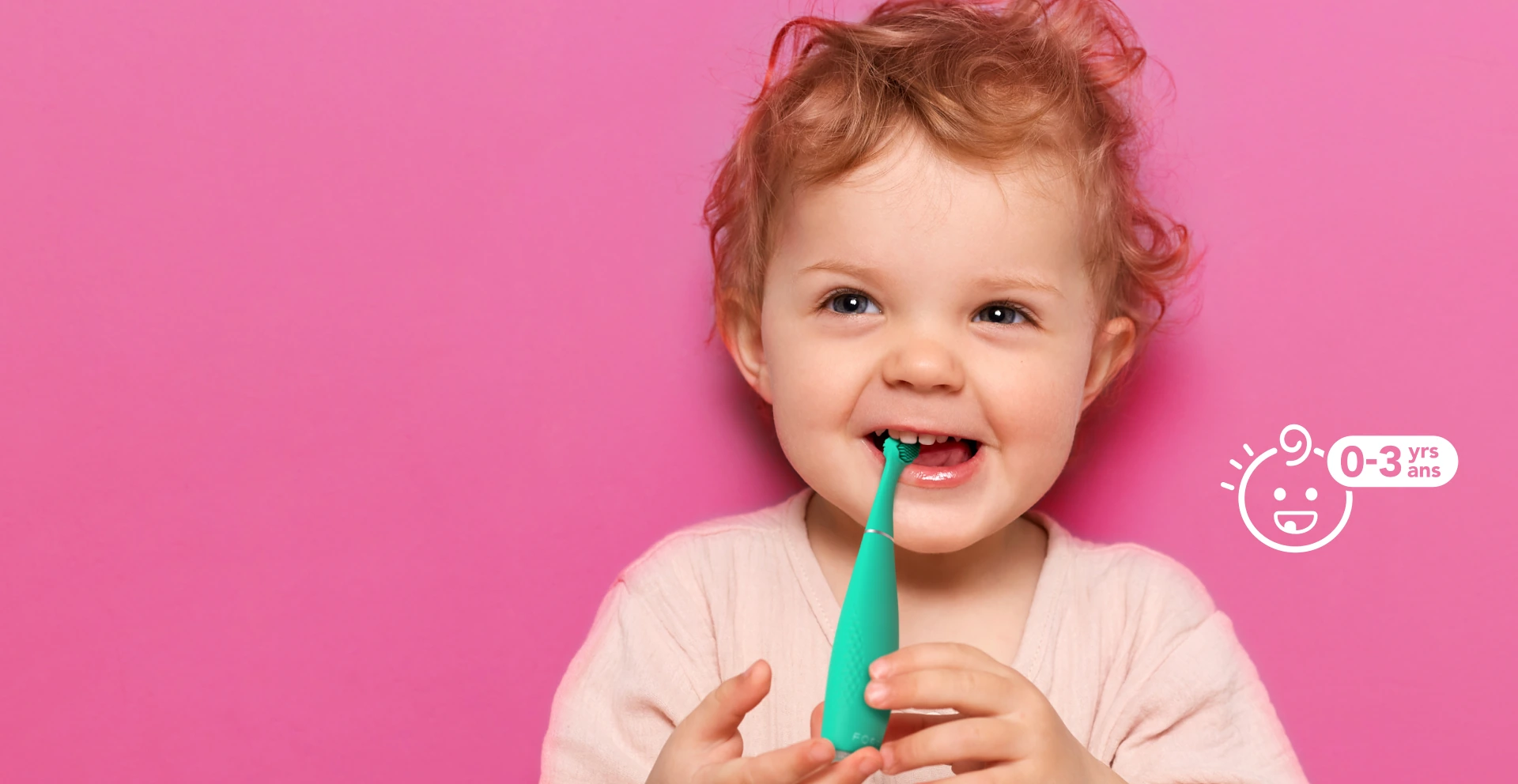 Smiling toddler holding a green FOREO issa 4 baby toothbrush