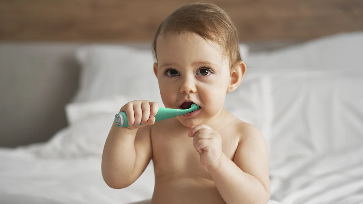 A baby using issa 4 baby silicone sonic toothbrush