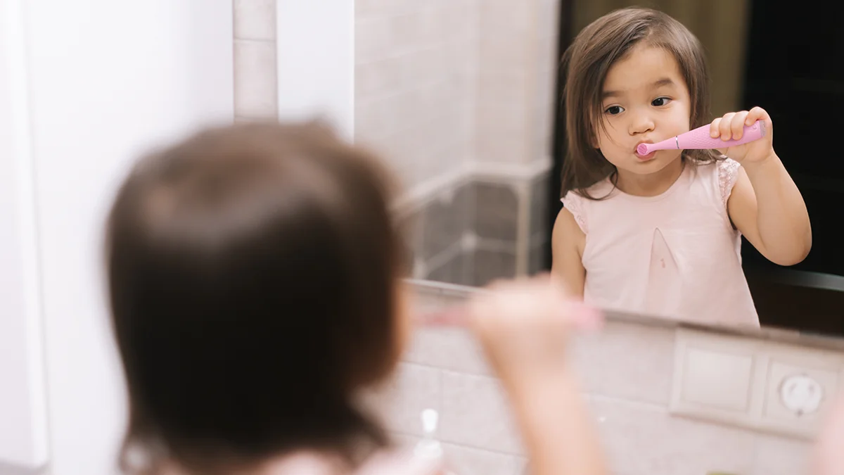 A young Asian baby girl brushing her teeth with issa 4 baby