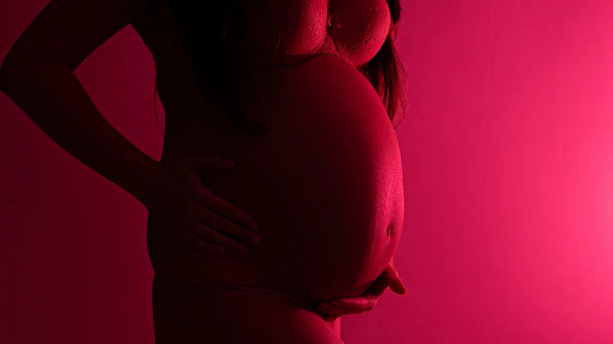 A pregnant women doing red light therapy