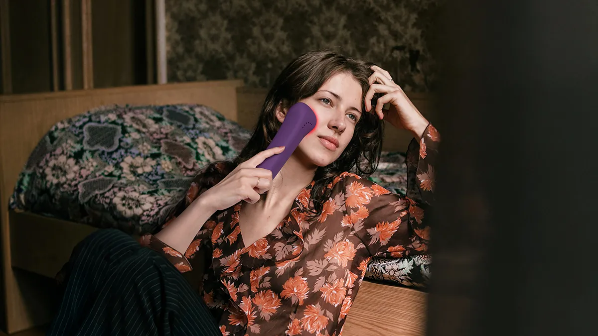 A woman using FAQ 501 full-spectrum red light therapy