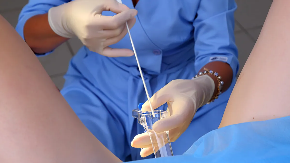 A woman at the gynecologist having a sample of the discharge taken