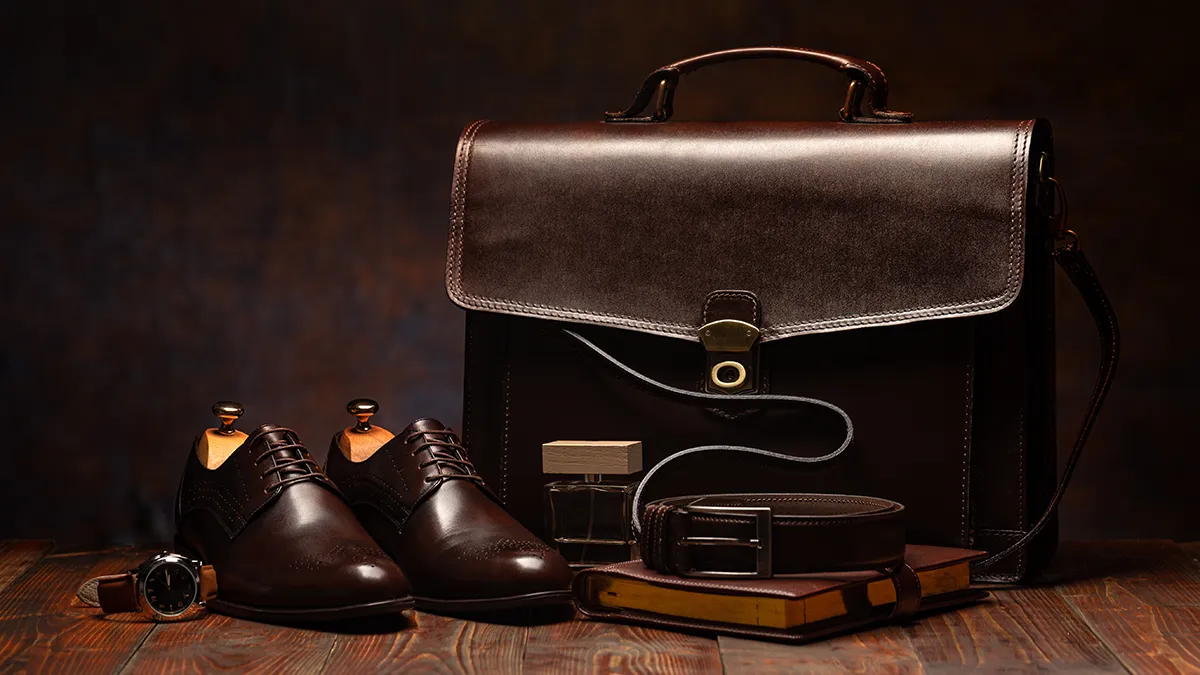 a shiny brown leather bag and shoes  on a dark background