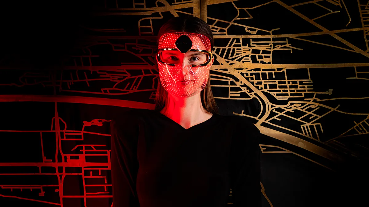 A woman wearing FAQ 202 red light therapy mask 