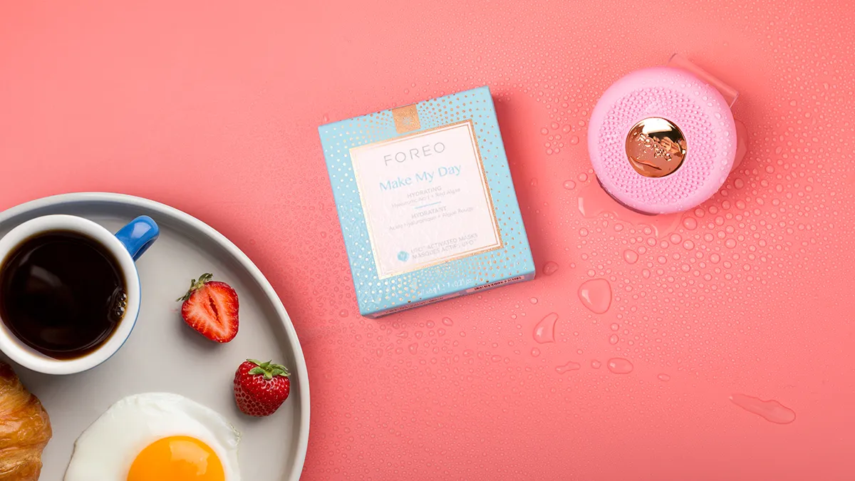 FOREO UFO 3 mini with UFO-activated mask near a breakfast on a pink background