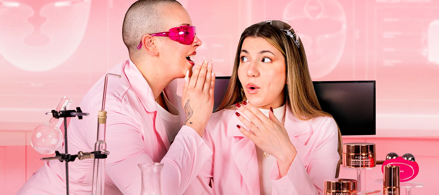 Two ladies in pink lab coats whispering about FOREO birthday skincar sale 