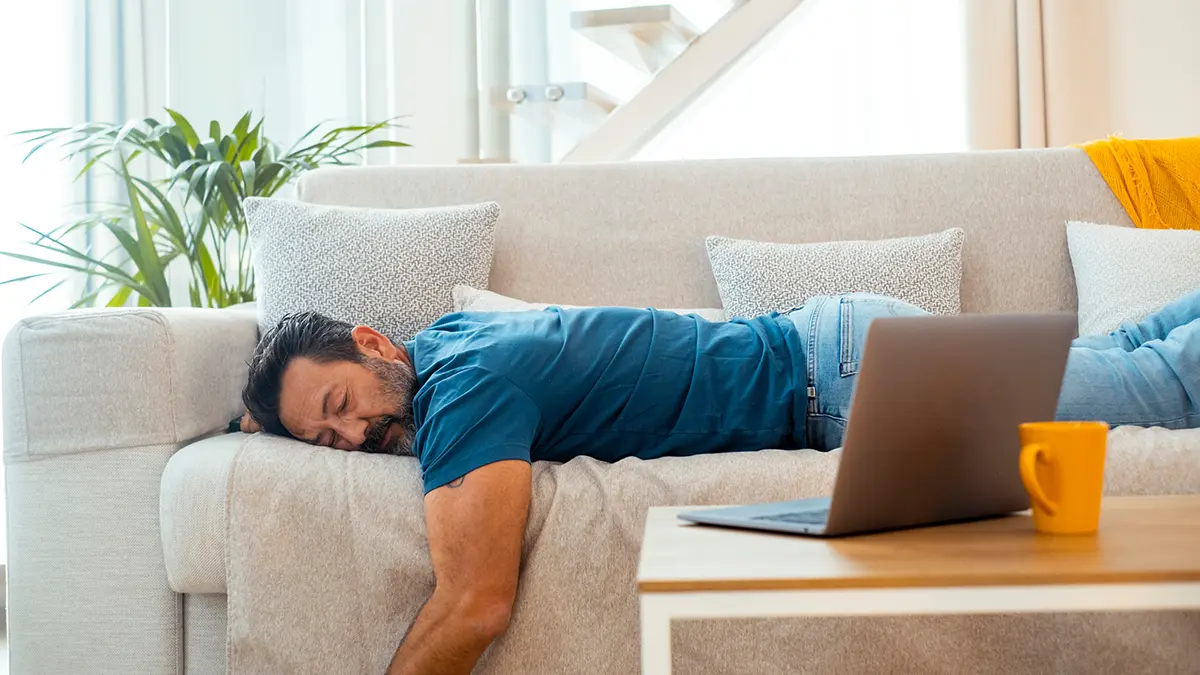 A toired attractive middle aged man sleeping on the couch