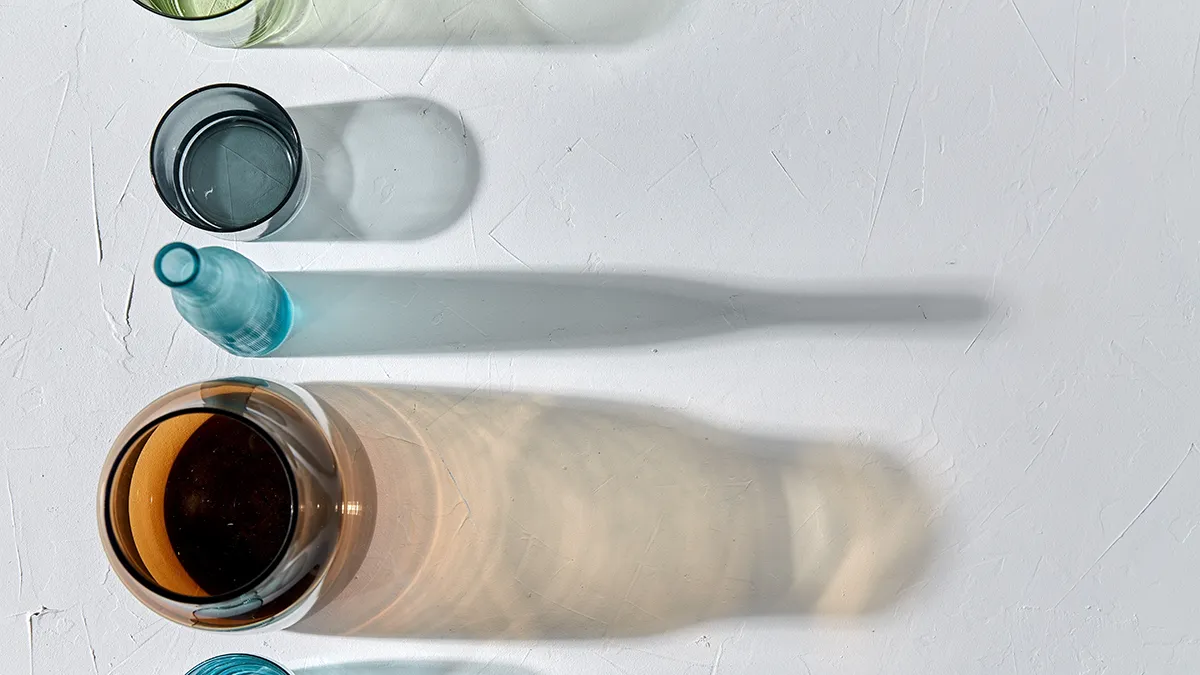 colorful glassware and their shades on white background