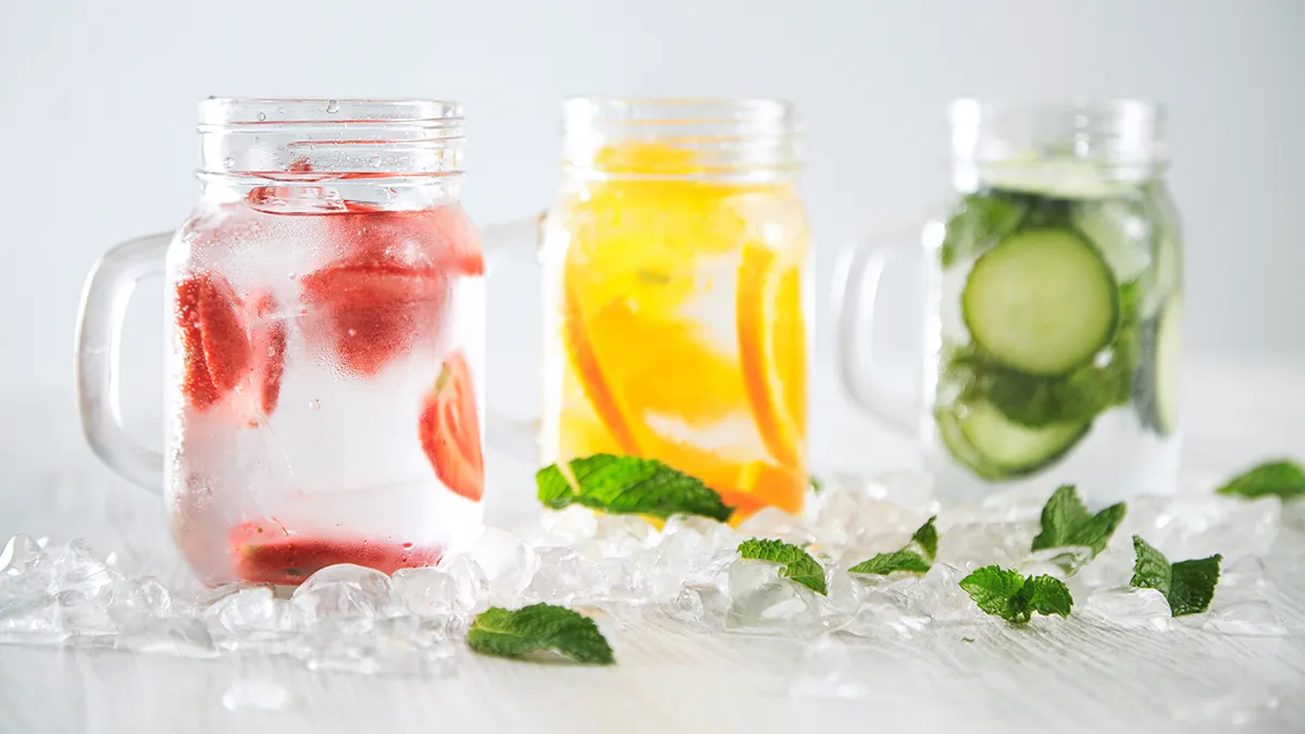 Water in jars with strawberries, lemon, and cucumber