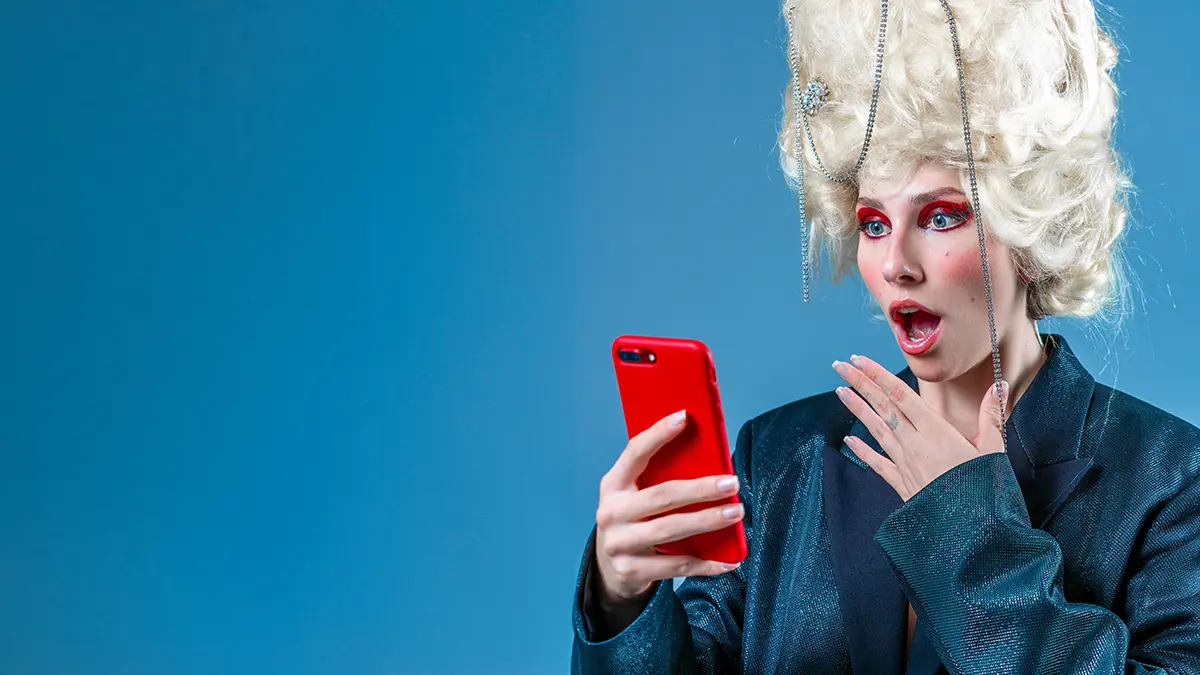 A woman with a renaissance wig looking surprised saving money buying online on her red phone