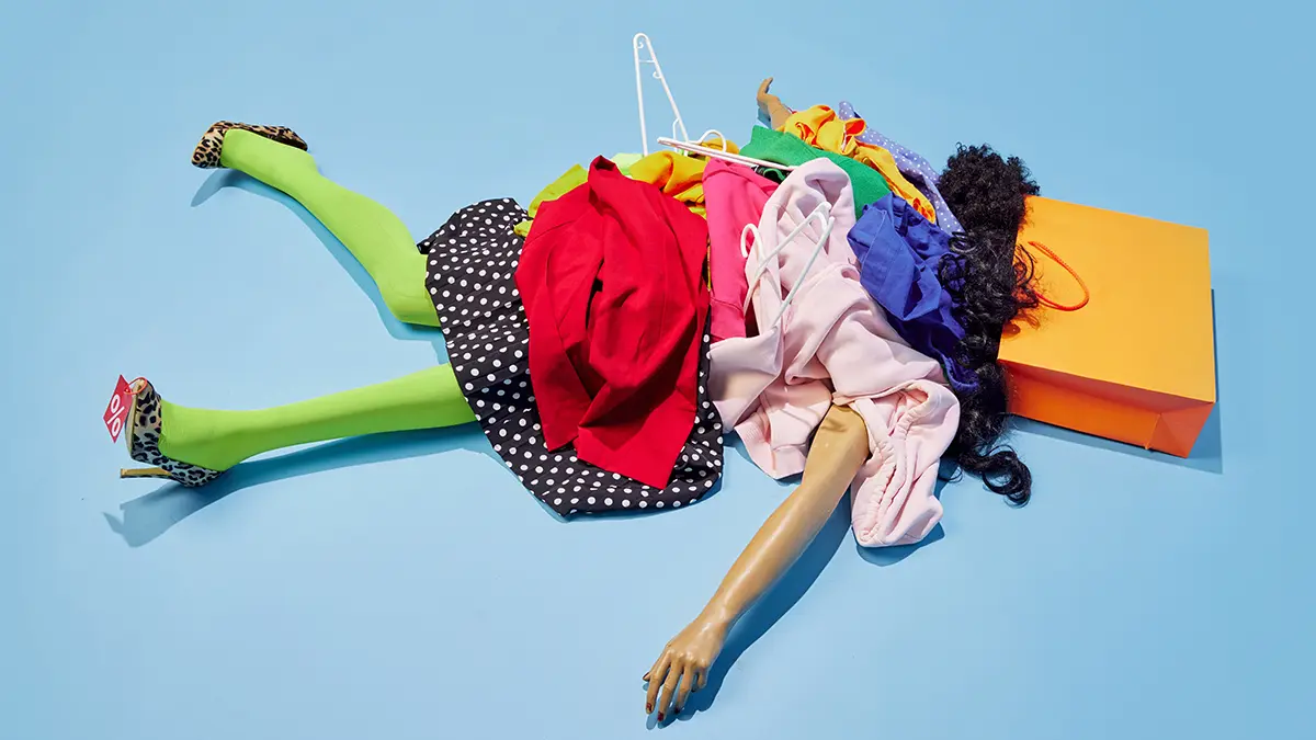 a body on the floor made out of a manequinne and colourful shopping bags