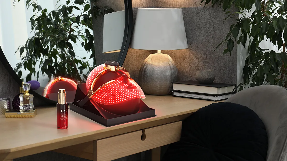 FAQ 202 plus NIR and red light therapy face mask on a vanity table in a tastefully decorated room