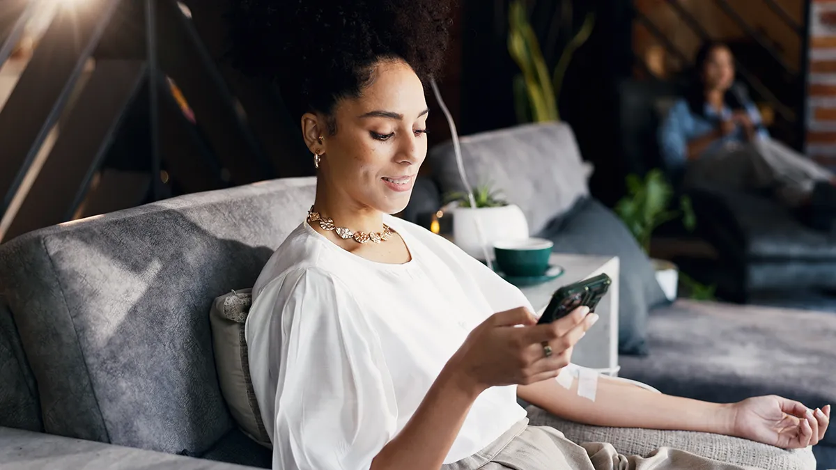 A woman using IV therapy and enjoying a nice scroll in a comfortable space
