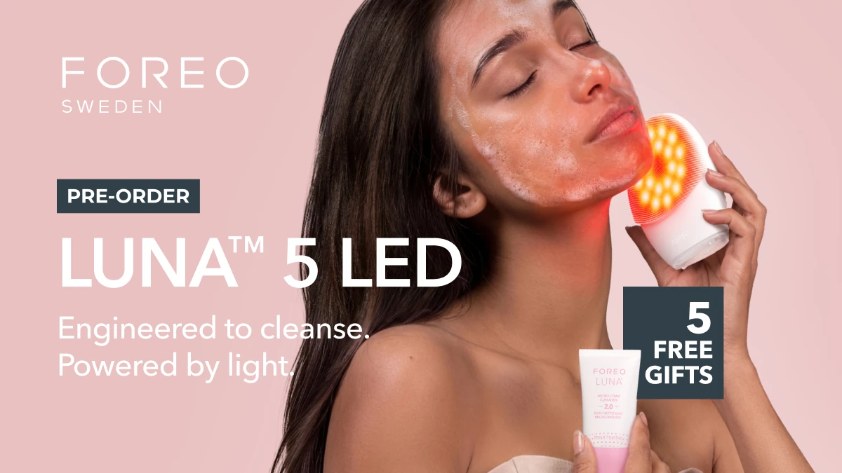 A young woman using LUNA 5 LED facial cleansing massager
