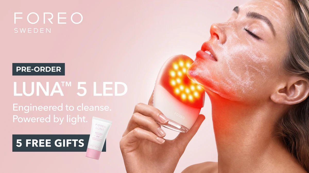 Woman using LUNA 5 red LED facial cleansing anti aging massage brush