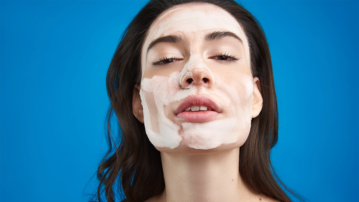 A woman with her chin definatly lifted and a face full of foam