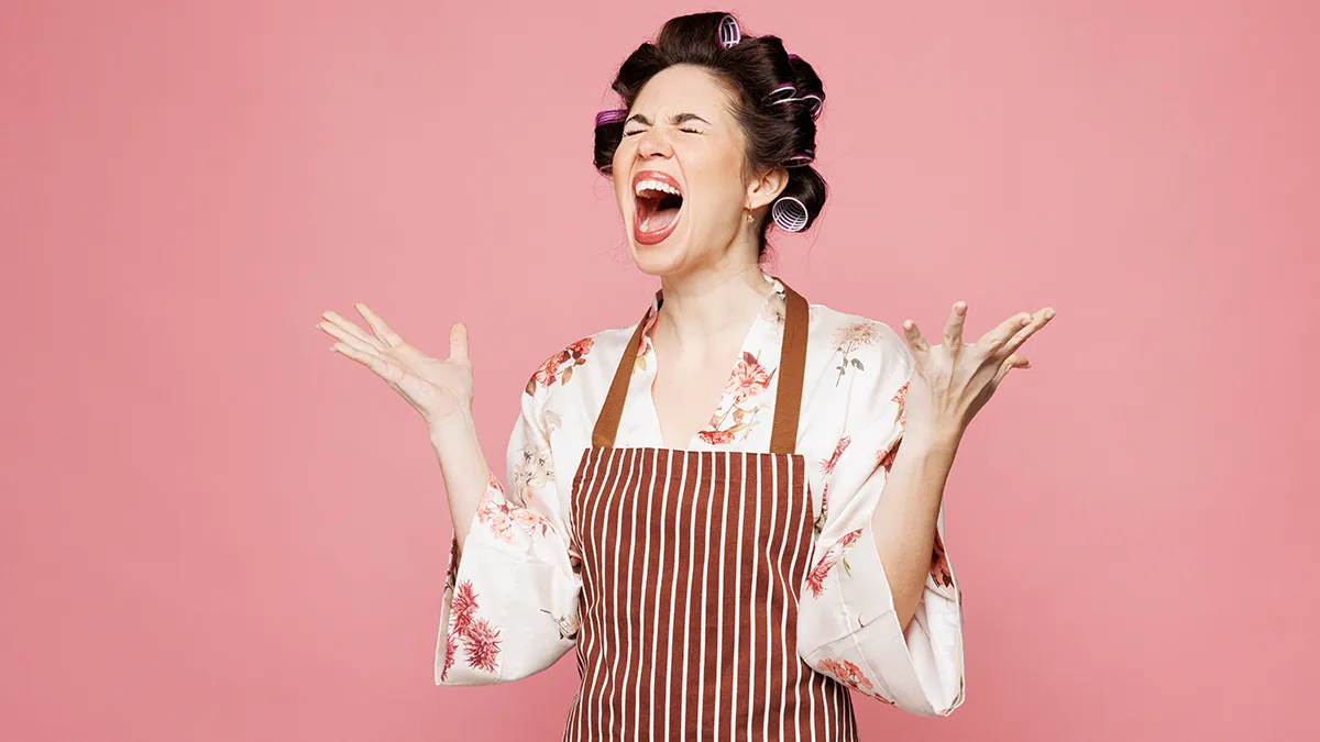 Mood changes in perimenopause, woman with rollers in her hair screaming on pink background