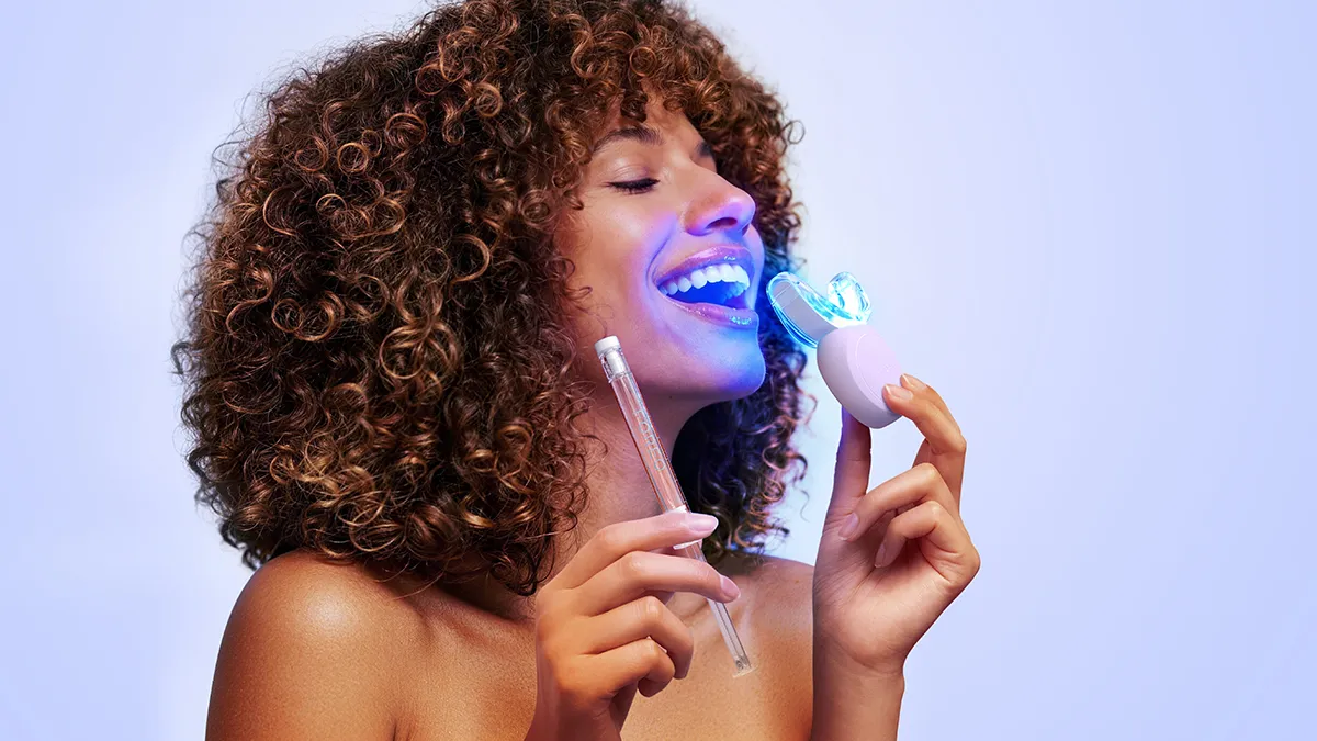 A young woman with a beautiful afro using issa LED bleach trays