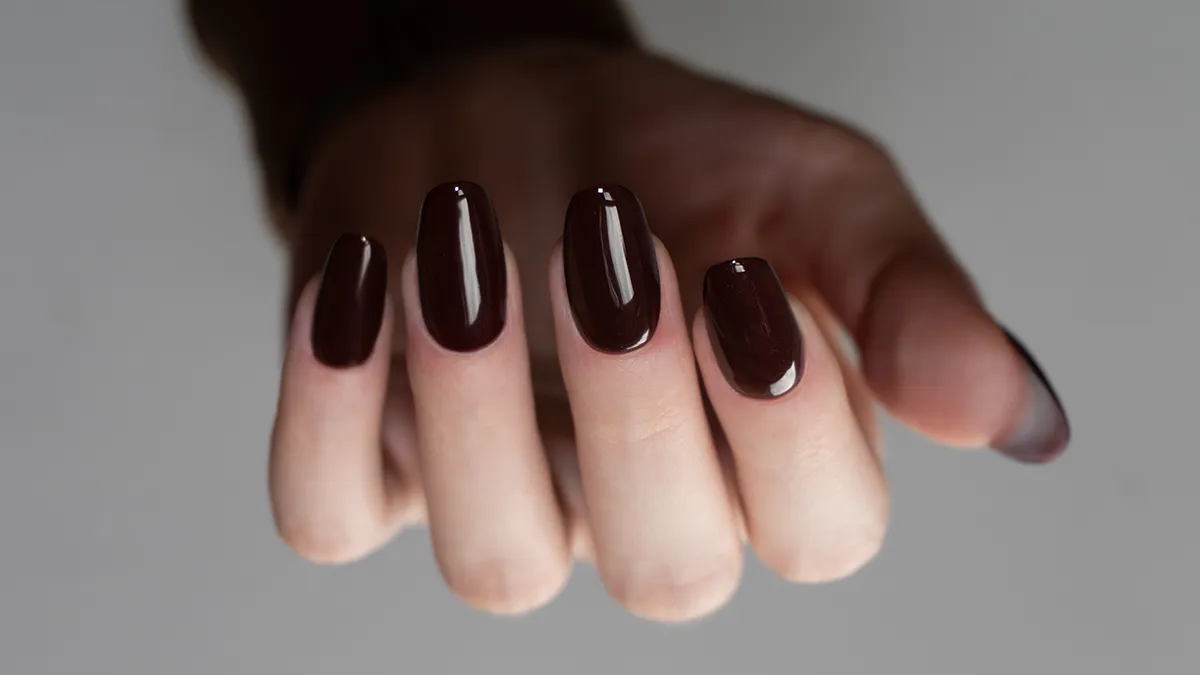 perfectly manicured dark nails with light and shadow interplay on the hand