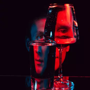 A face in red LED light broken visually by looking at it through glass