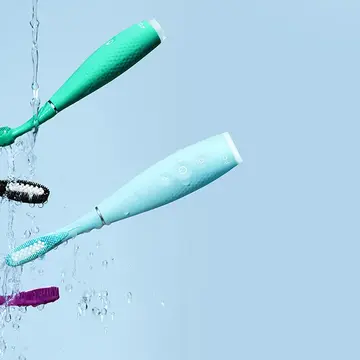 Issa 4 collection silicone sonic electric toothbrushes mid air on a light blue background