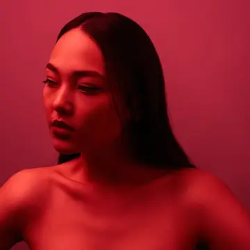 A gorgeous Asian descent woman in a glowing red light