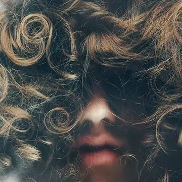 A woman with curly hair from frog perspective