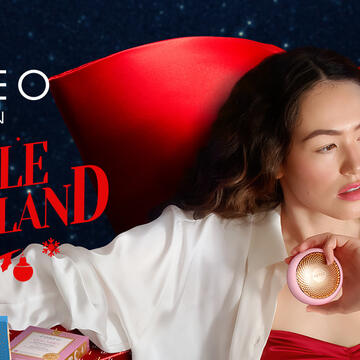 A woman using FOREO devices in a holiday setting