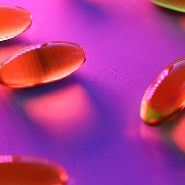 Transulcent pills under purple neon light  