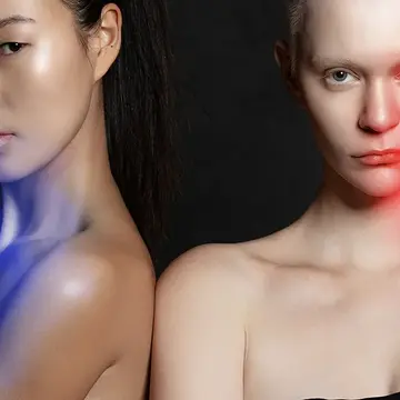 Two women using FAQ 202 plus NIR and red light therapy face masks with blue and red light therapy