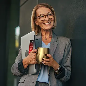 A mature vital business woman drinking vitamins for womens health from a golden cup