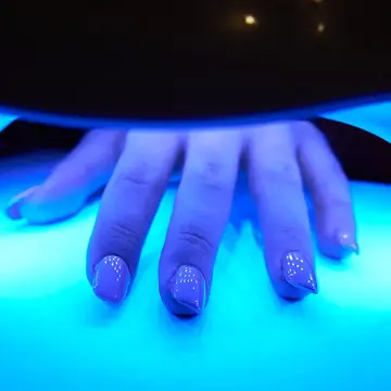 gel manicure curing in a blue light for nails manicure 