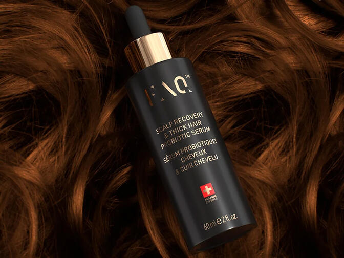 FAQ™ Scalp Recovery & Thick Hair Probiotic Serum on a bed of soft, strong curls