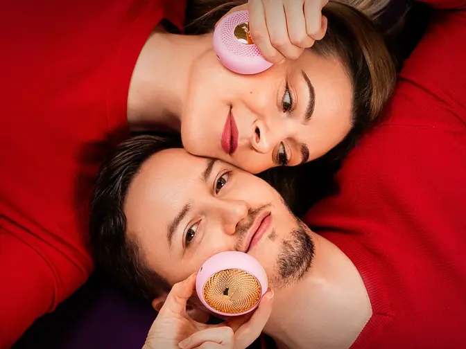 A man and woman enjoying Valentine's Day sales gifts, lovingly laying head to head, and treating each other to a UFO facial spa