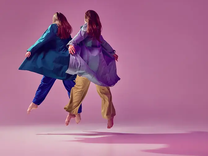 Two contemporary dancers frozen in the air as if they were fyling 