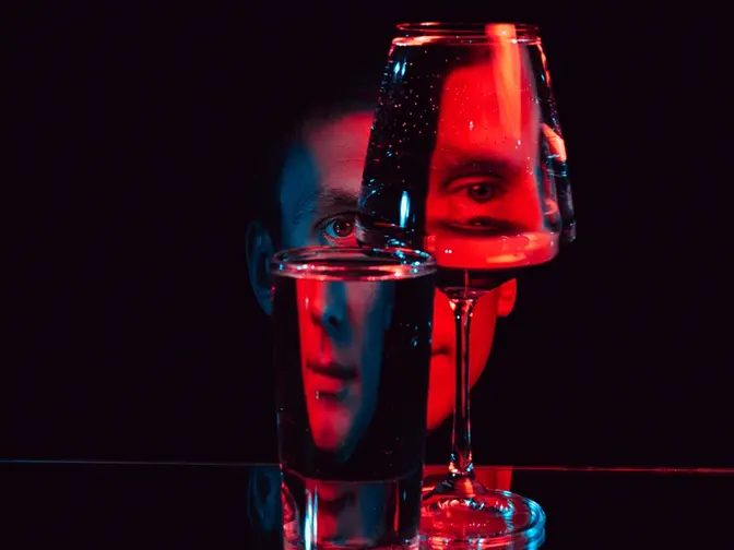 A face in red LED light broken visually by looking at it through glass