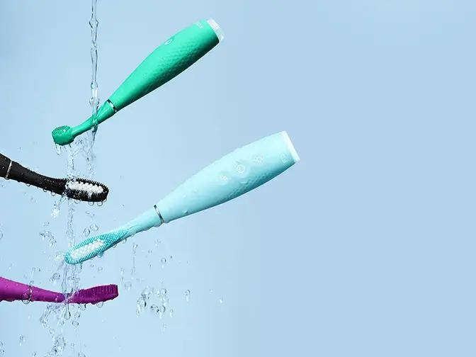 Issa 4 collection silicone sonic electric toothbrushes mid air on a light blue background