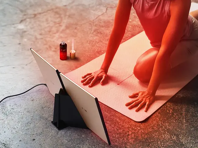Woman doing yoga in fron of FAQ DUAL LED PANEL red light therapy at home device