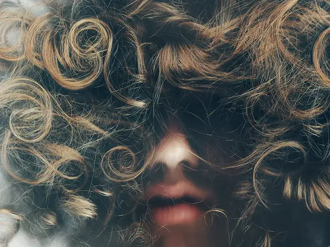 A woman with curly hair from frog perspective