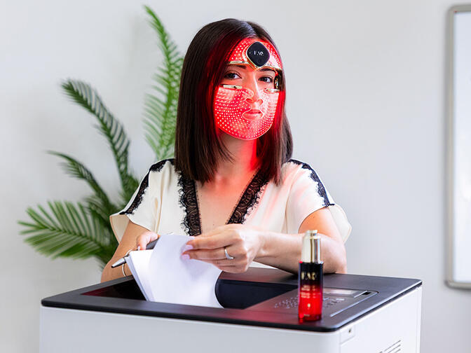 A woman using FAQ 202 mask in the office