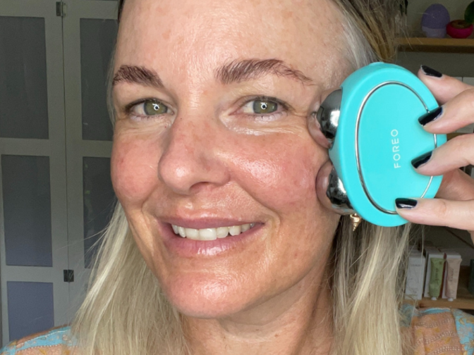 Amanda ramsay gliding FOREO BEAR™ microcurrent device over her cheekbones