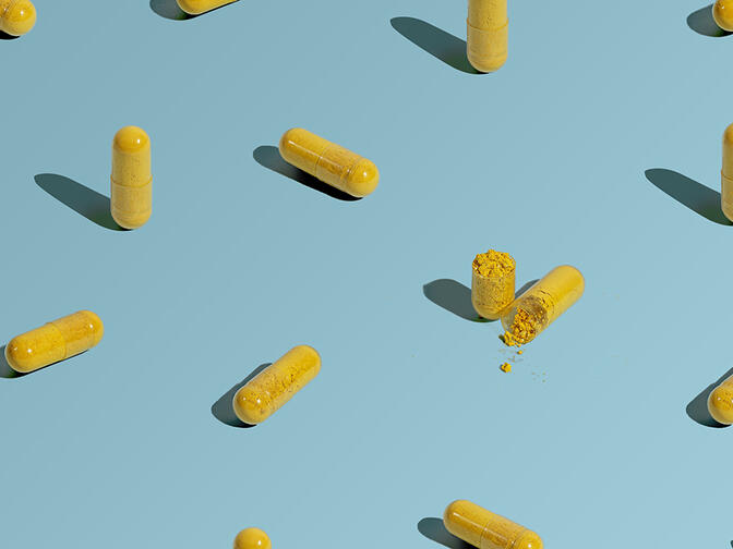 A pattern of yellow berberine pills on a light blue surface