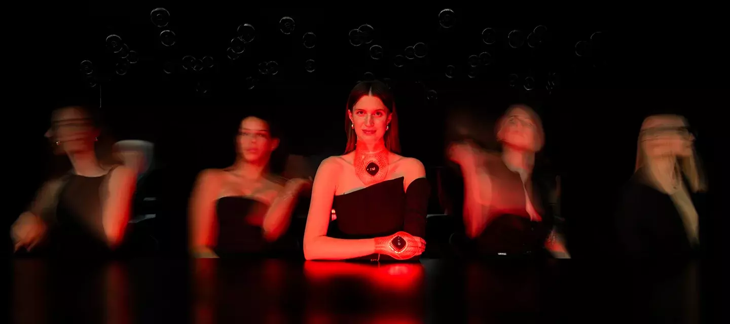 Beautiful young women wearing FAQ 211 and FAQ 221 LED light therapy devices on a dark background Beautiful young women wearing FAQ 211 and FAQ 221 LED light therapy devices on a dark background