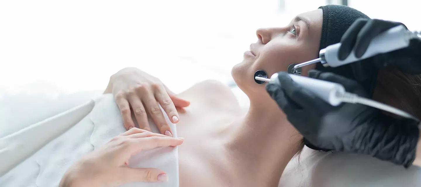 A beautiful woman having a microcurrent facial in a clinical setting A beautiful woman having a microcurrent facial in a clinical setting
