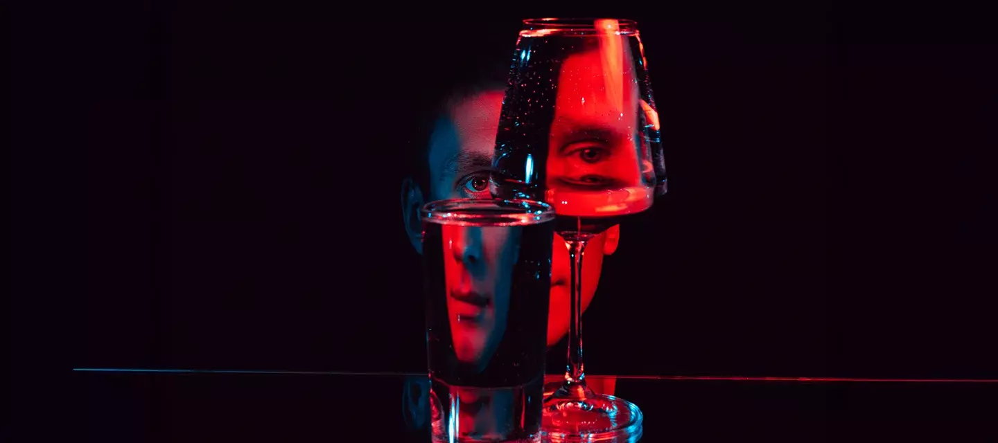 red light therapy dangers A face in red LED light broken visually by looking at it through glass